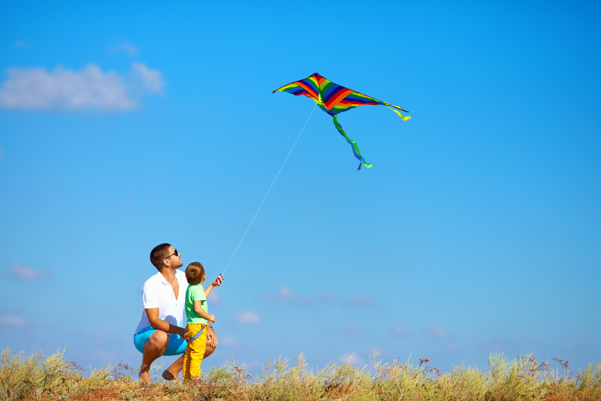Father and son playing with kite outside