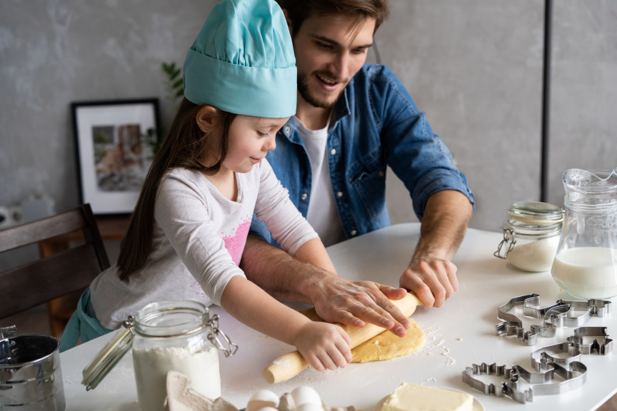 Father and daughter rolling pastry at home